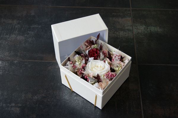 Weisse Schachtel mit rosa Trockenblumen