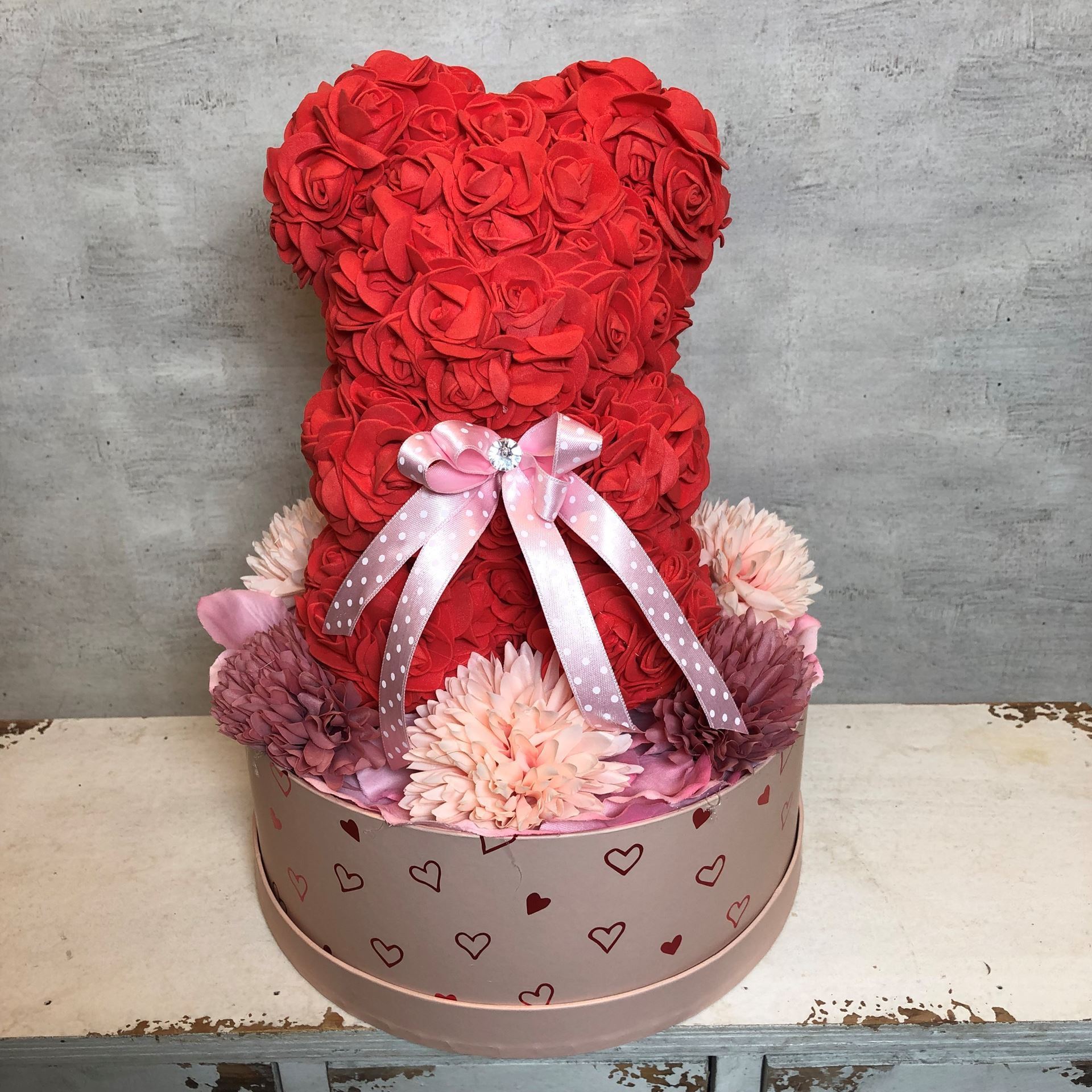 Noble boîte d'ours en rose avec des cœurs en rouge et rose